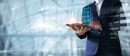 Business professional analyzing financial data on a tablet with abstract graphs in background.