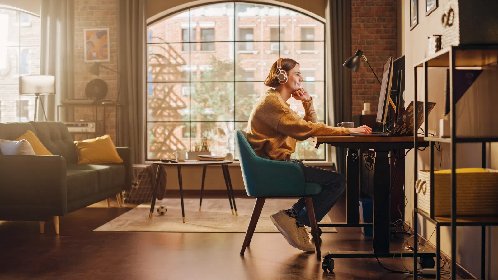 A woman working at a desk in a cozy home office, surrounded by natural light and stylish decor.