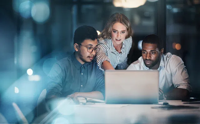 a group of people looking at a laptop