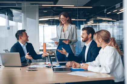 Professionals collaborating in a modern office setting during a business meeting.