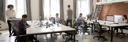 Modern office space with engaged employees working and collaborating in a bright setting.