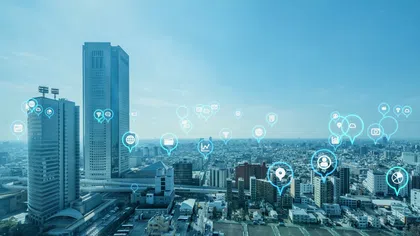 A city skyline featuring tech icons and connectivity symbols in a digital landscape.