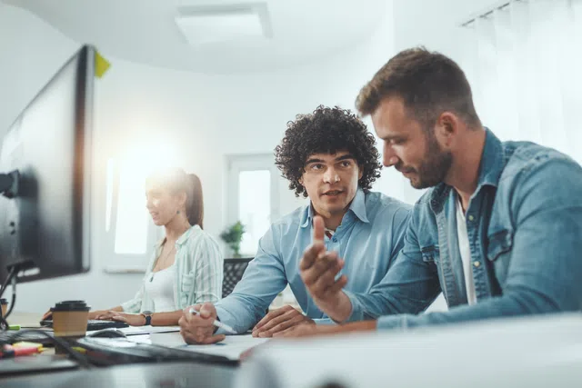 A group of diverse professionals collaborating in a modern office space, discussing ideas and projects.