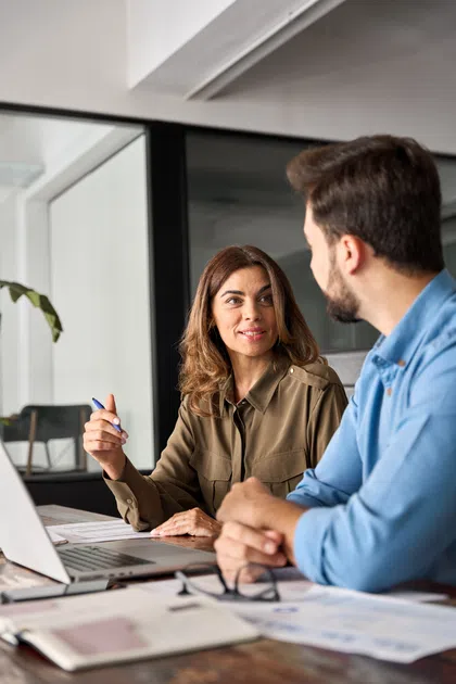 Professional woman discussing ideas with a colleague in a modern office setting.