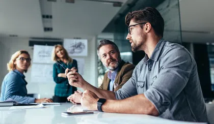 Business team discussing ideas in a modern office setting during a meeting.