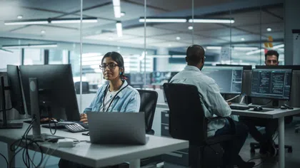 A diverse team of professionals working at computers in a modern office space.