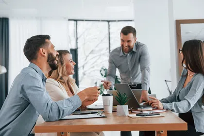 Business team engaged in a discussion around a table in a modern office setting.