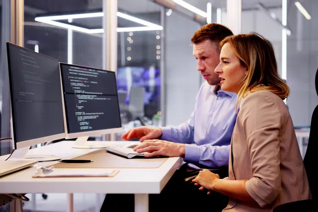 a man and a woman looking at a computer screen