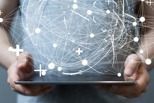 Person holding a tablet, surrounded by digital connections and abstract data flow.