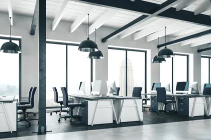 Modern office interior with desks, chairs, and large windows showcasing a city view.